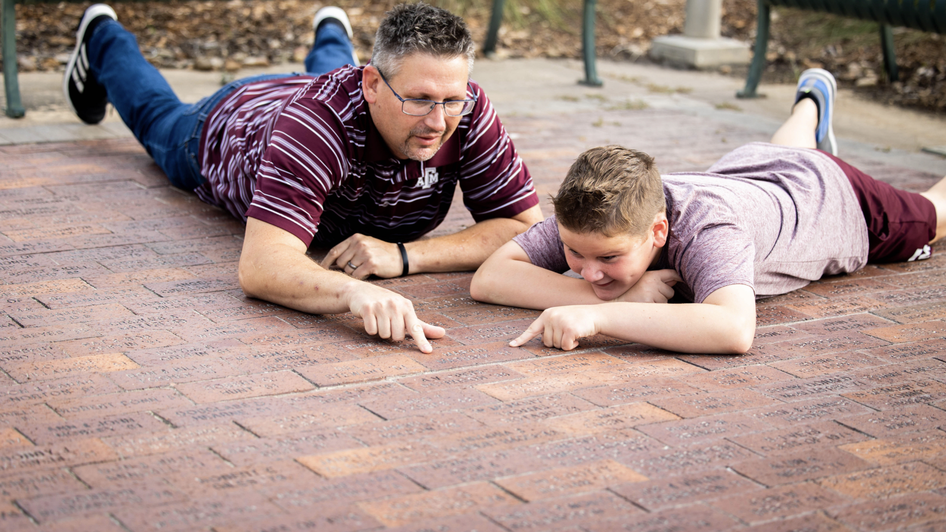 A father and his son look at a brick on the Corps Center brick plaza.