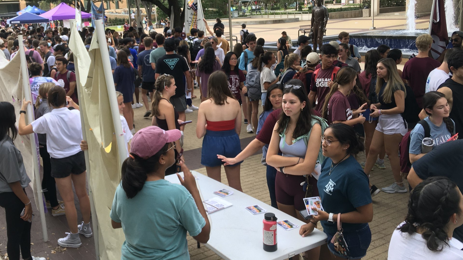 Students getting information at FLO tables by Rudder Fountain